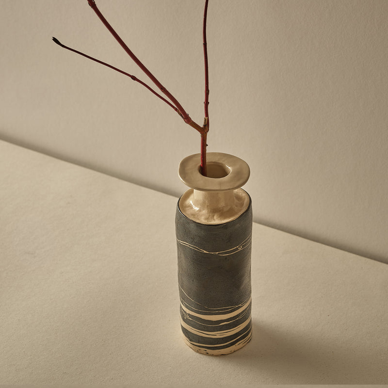 Decorative vase with a branch on a beige background